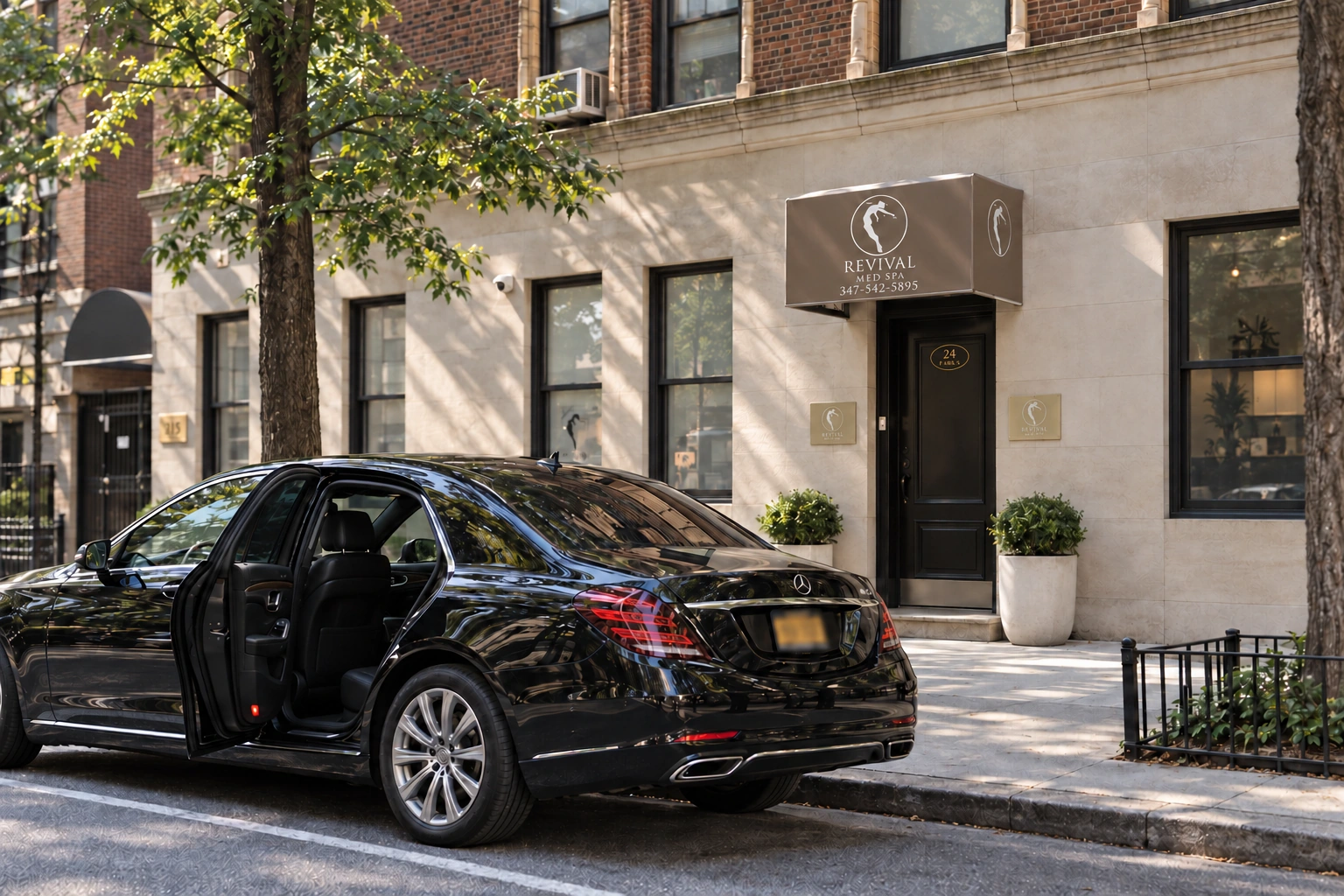 A black sedan with its rear door open outside Revival — campaign imagery